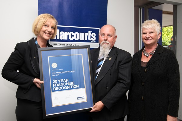 Phillip Kenny and his wife Marie receiving a special framed certificate from Harcourts Chief Operations Officer Jo Clifford